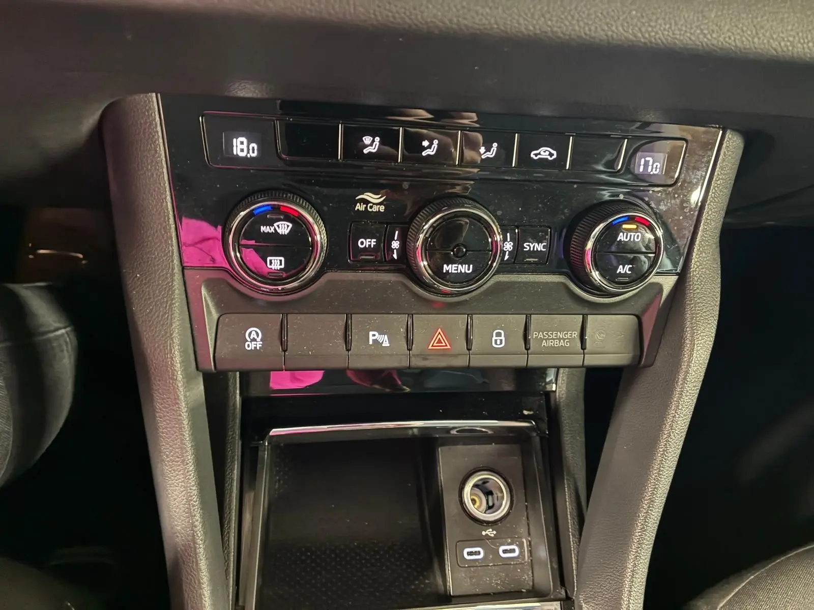 Gros plan sur la console centrale du Skoda Karoq 2023, avec commandes climatisation et ports USB-C visibles.