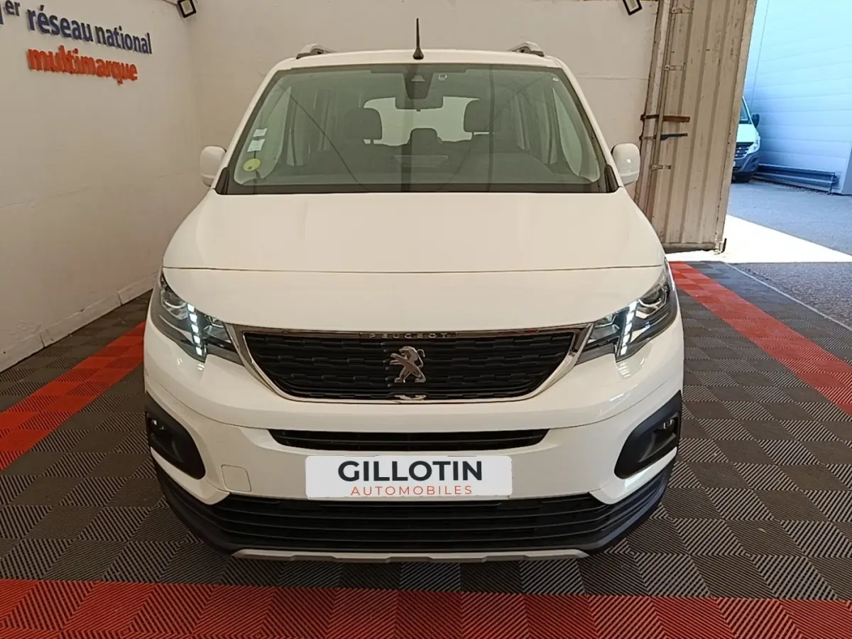 Vue avant d'un Peugeot Rifter blanc 2020 avec calandre noire et feux LED allumés en intérieur.