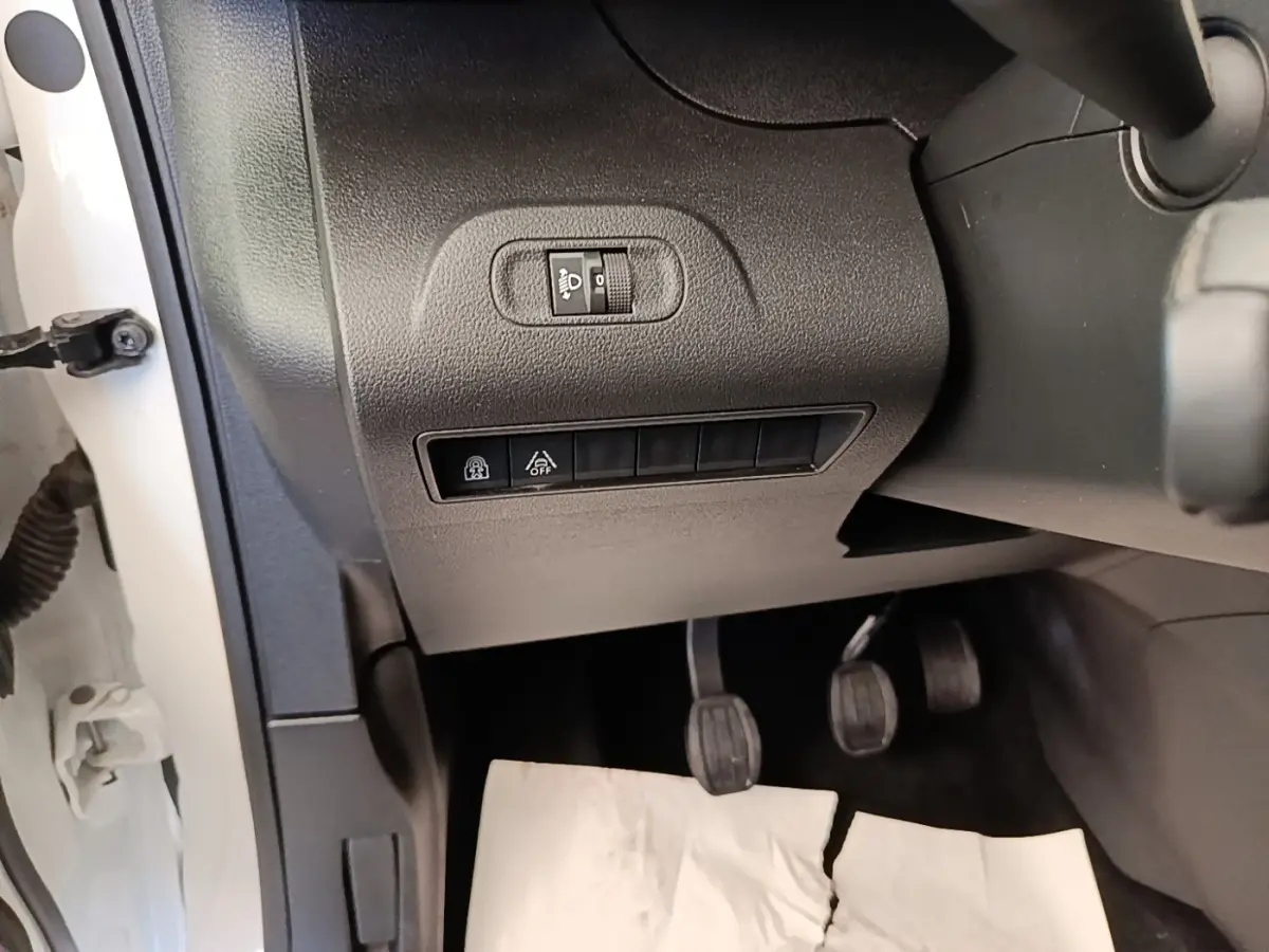 Vue intérieure côté gauche du Peugeot Rifter blanc 2020, montrant les commandes d'éclairage et les pédales.