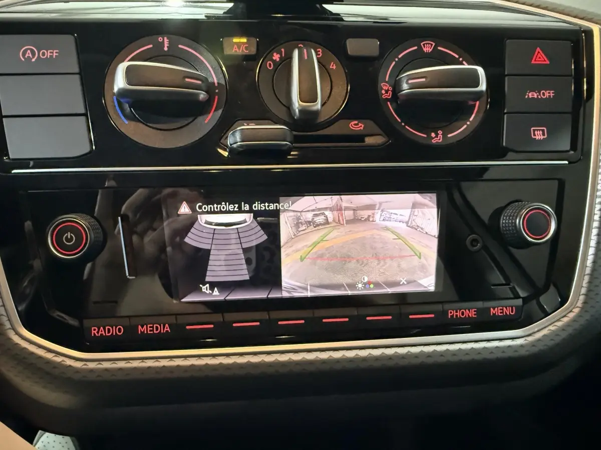 Tableau de bord du Volkswagen Up 1.0 65 Active 2022 montrant l'écran de caméra de recul et commandes de climatisation.