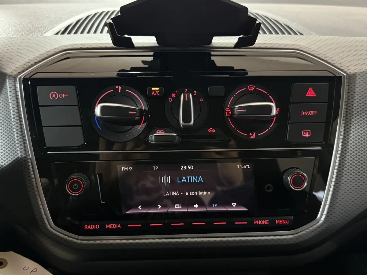 Tableau de bord noir de Volkswagen Up 1.0 65 Active 2022 avec commandes climatisation et écran radio allumé