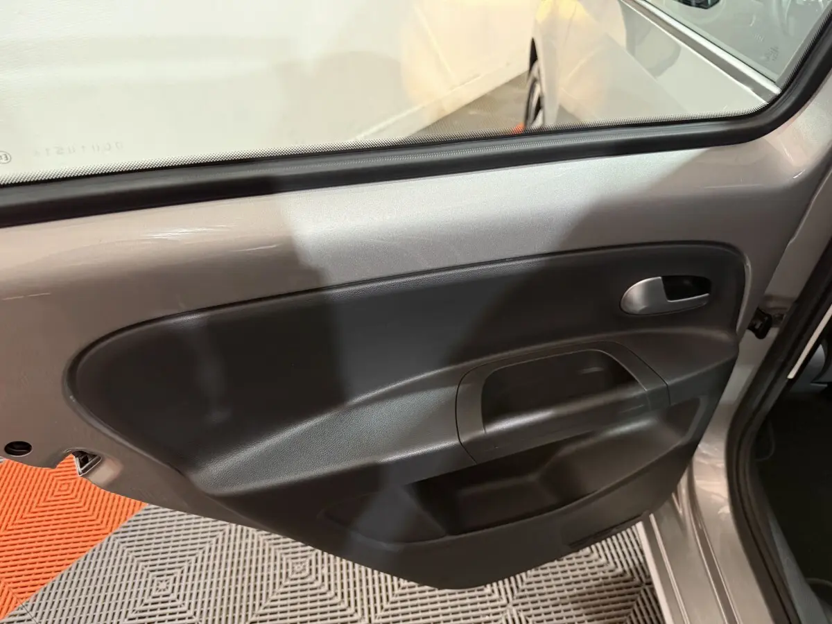 Porte arrière côté droit ouverte d'une Volkswagen Up gris foncé, montrant la garniture intérieure noire simple.