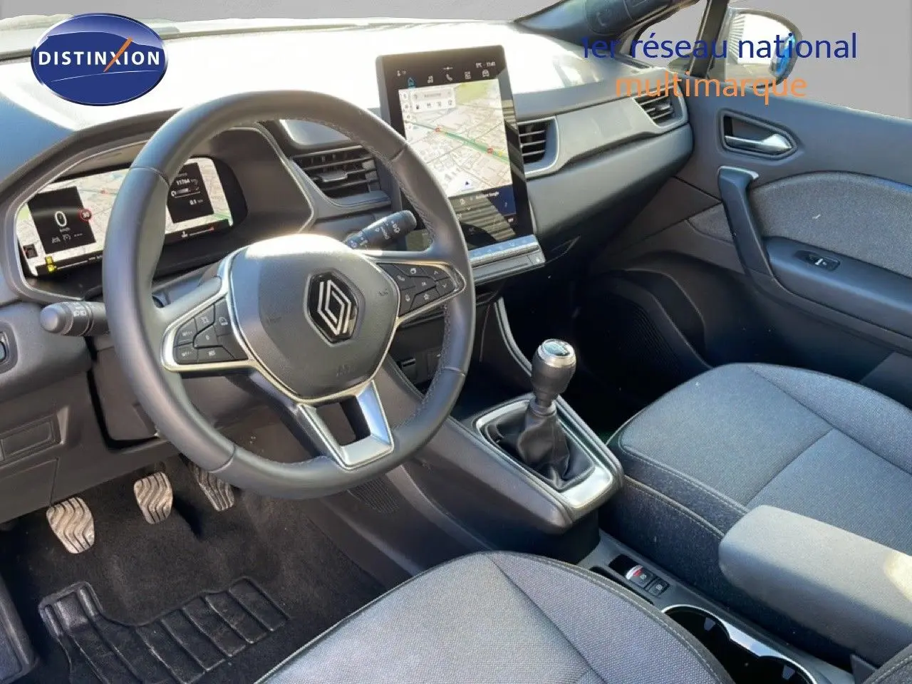 Vue intérieure côté conducteur du Renault Captur 2025, montrant volant cuir, tableau de bord numérique et écran tactile vertical.