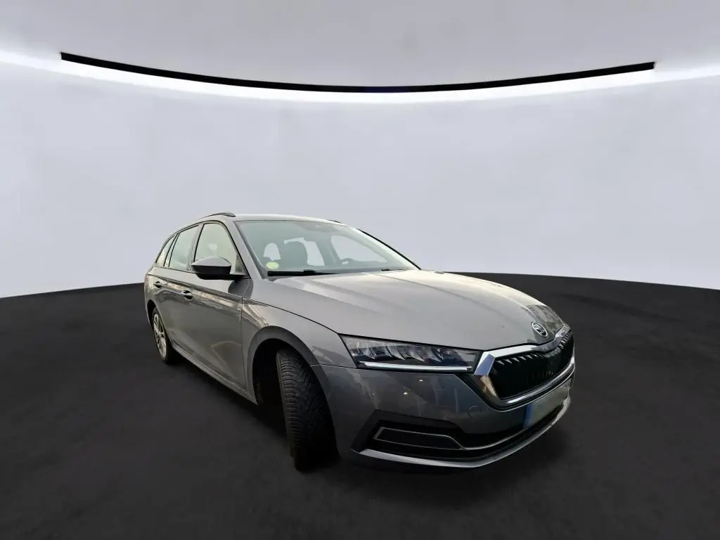Vue 3/4 avant gauche d'une Skoda Octavia Combi gris métallisé avec calandre chromée et jantes alliage 16 pouces.