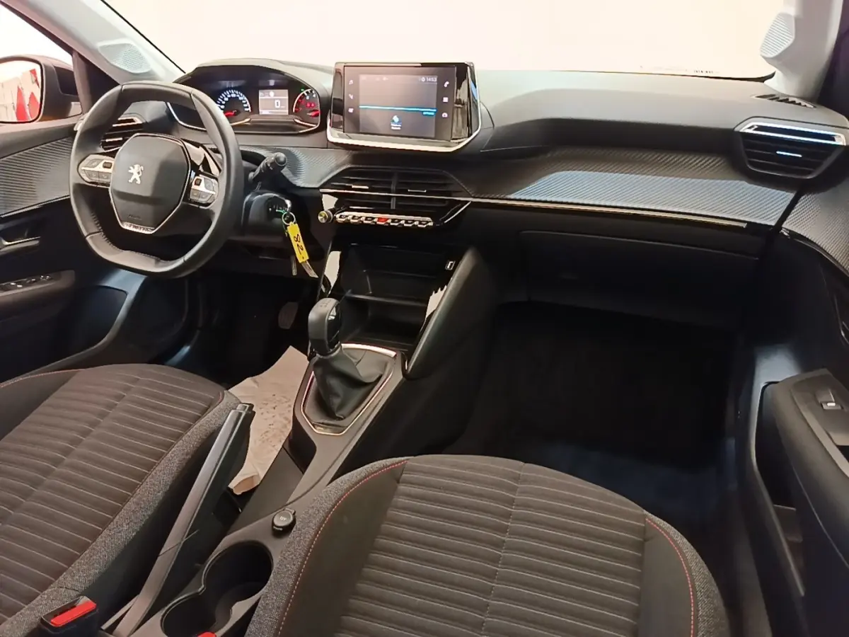 Intérieur de la Peugeot 208 PureTech 75 S&S Active Pack 2023, vue avant centrée sur tableau de bord et volant cuir multifonctions.