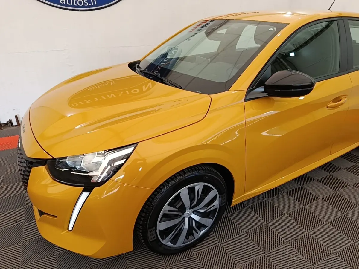 Vue 3/4 avant droit d'une Peugeot 208 jaune vif avec phares LED et rétroviseurs noirs brillants.