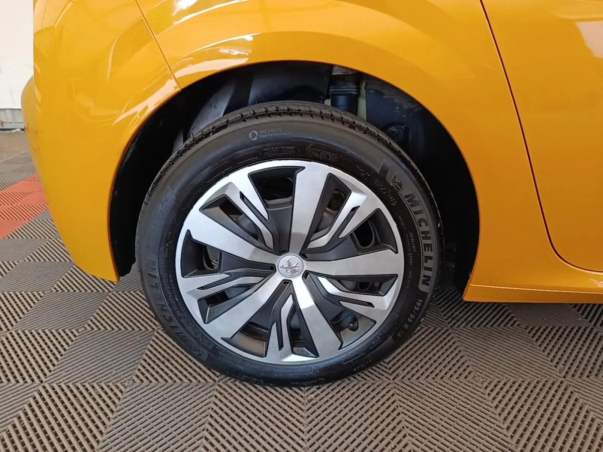 Gros plan sur la roue avant droite d'une Peugeot 208 jaune 2023 avec jante alliage et pneu Michelin.