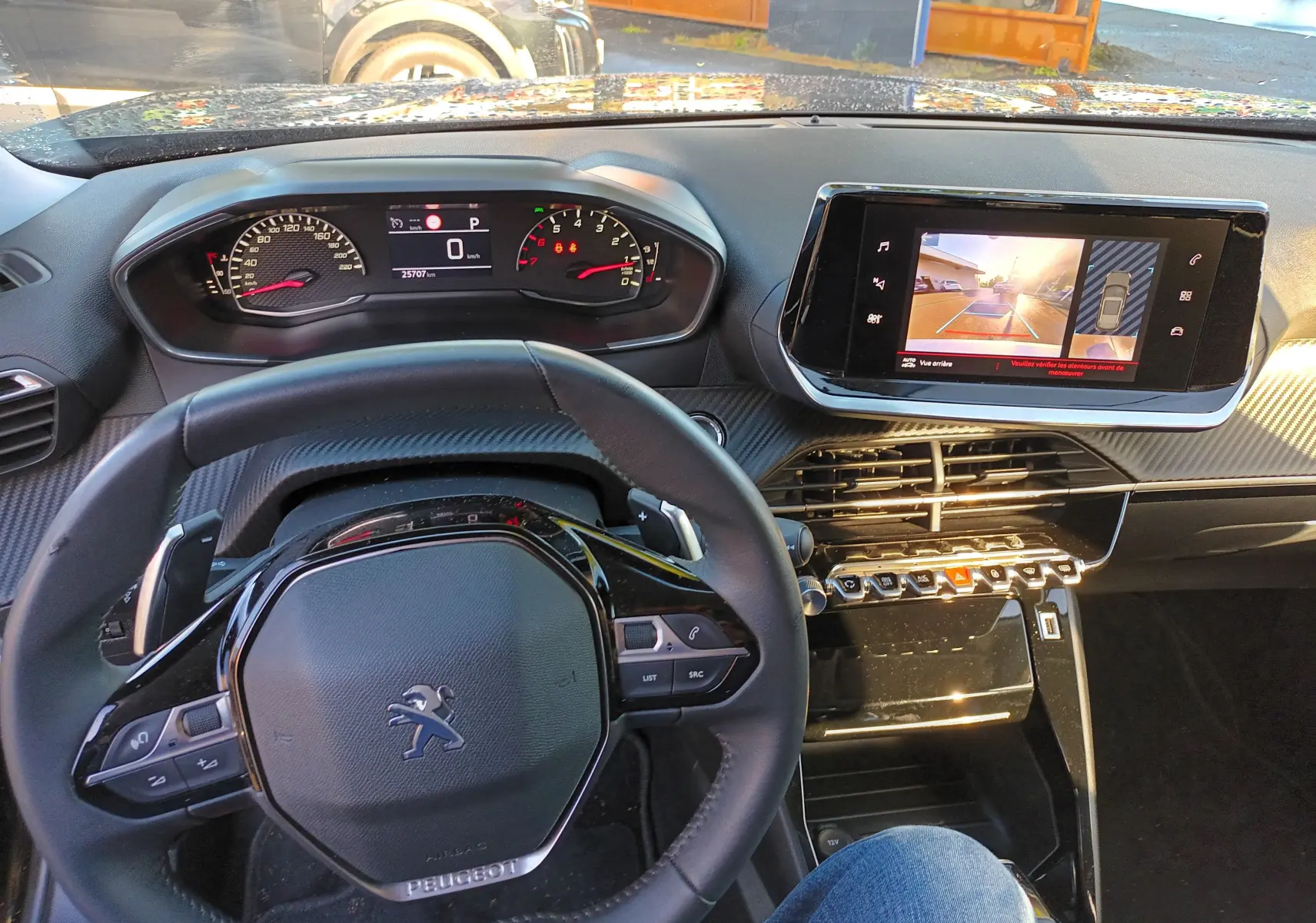 Vue intérieure du tableau de bord et volant noir du Peugeot 2008 PureTech 130 Allure 2022 avec écran tactile affichant la caméra de recul.