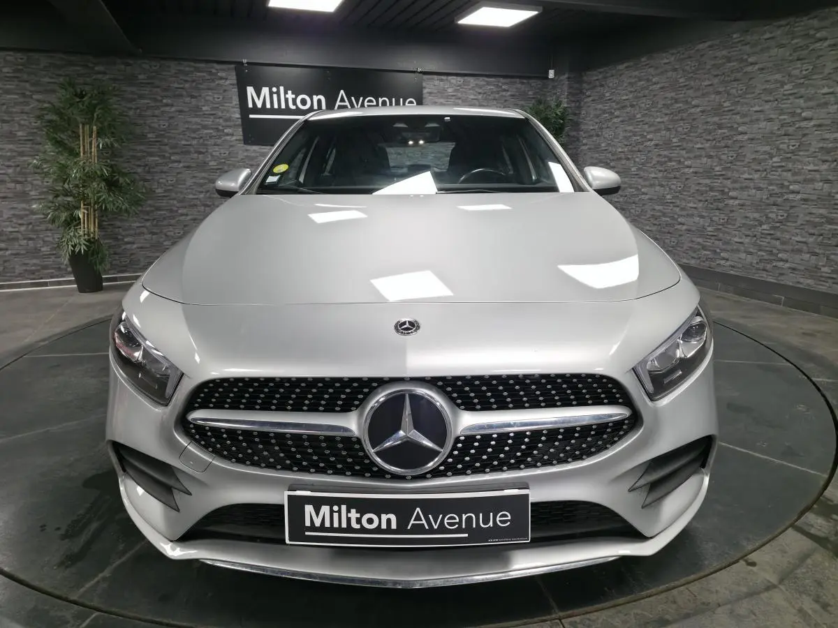 Vue frontale d'une Mercedes Classe A 200 d AMG Line gris métallisé avec calandre diamant et logo central lumineux.