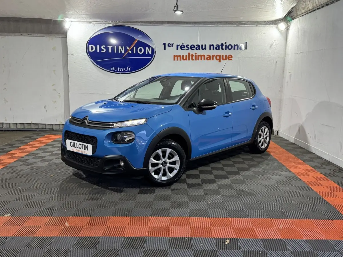 Citroën C3 bleu vue 3/4 avant droit, avec calandre noire et jantes argentées en showroom.