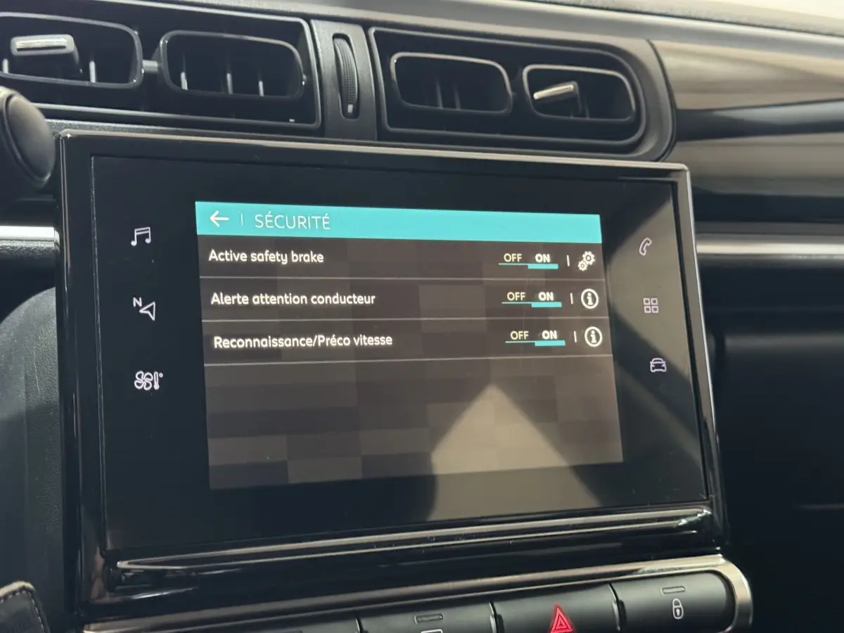 Écran tactile du système de sécurité dans l'habitacle de la Citroën C3 bleu, vue rapprochée du tableau de bord.