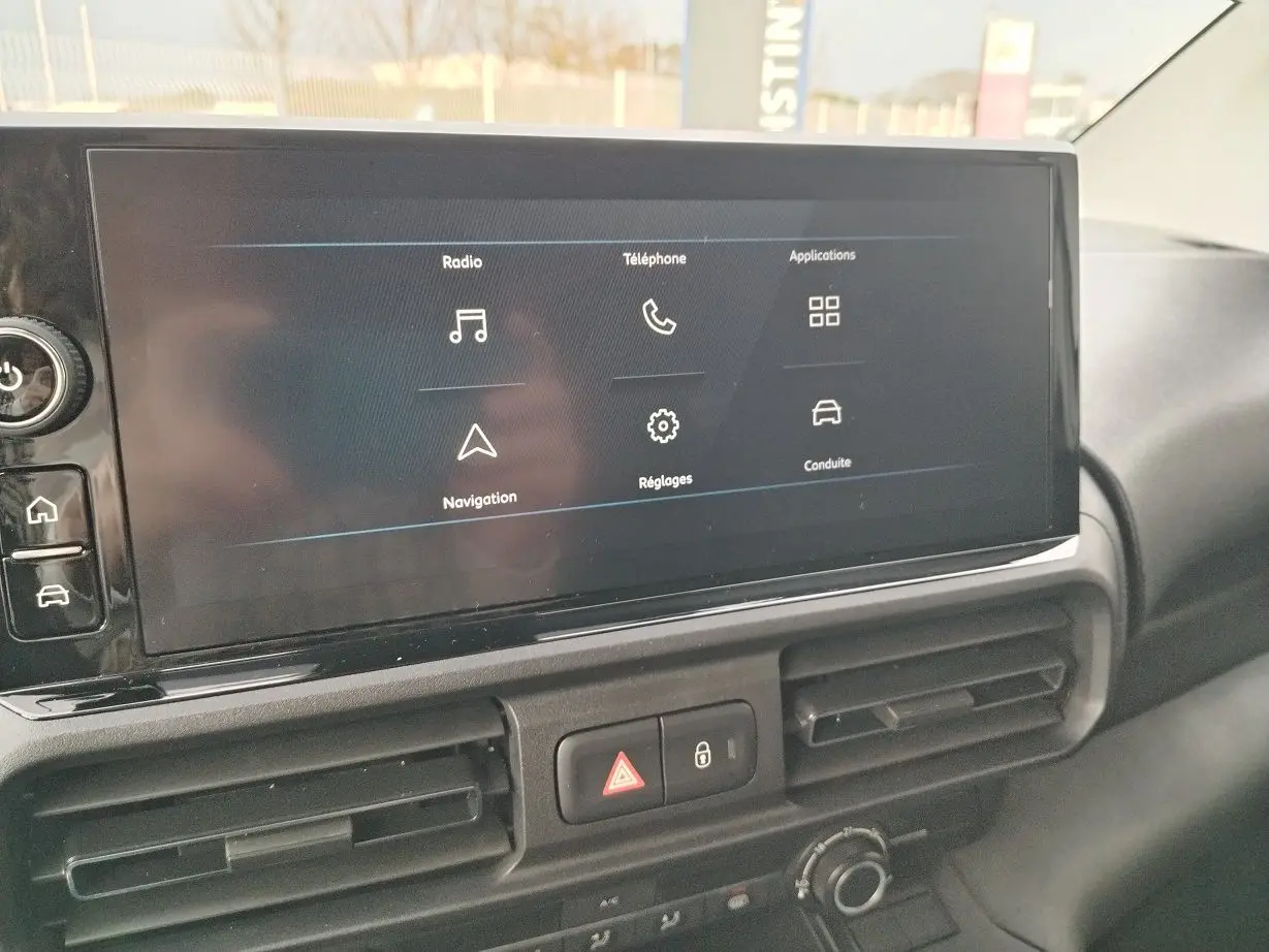 Écran tactile central du Peugeot Partner Fourgon blanc Icy 2025, affichant les menus radio, téléphone et navigation.