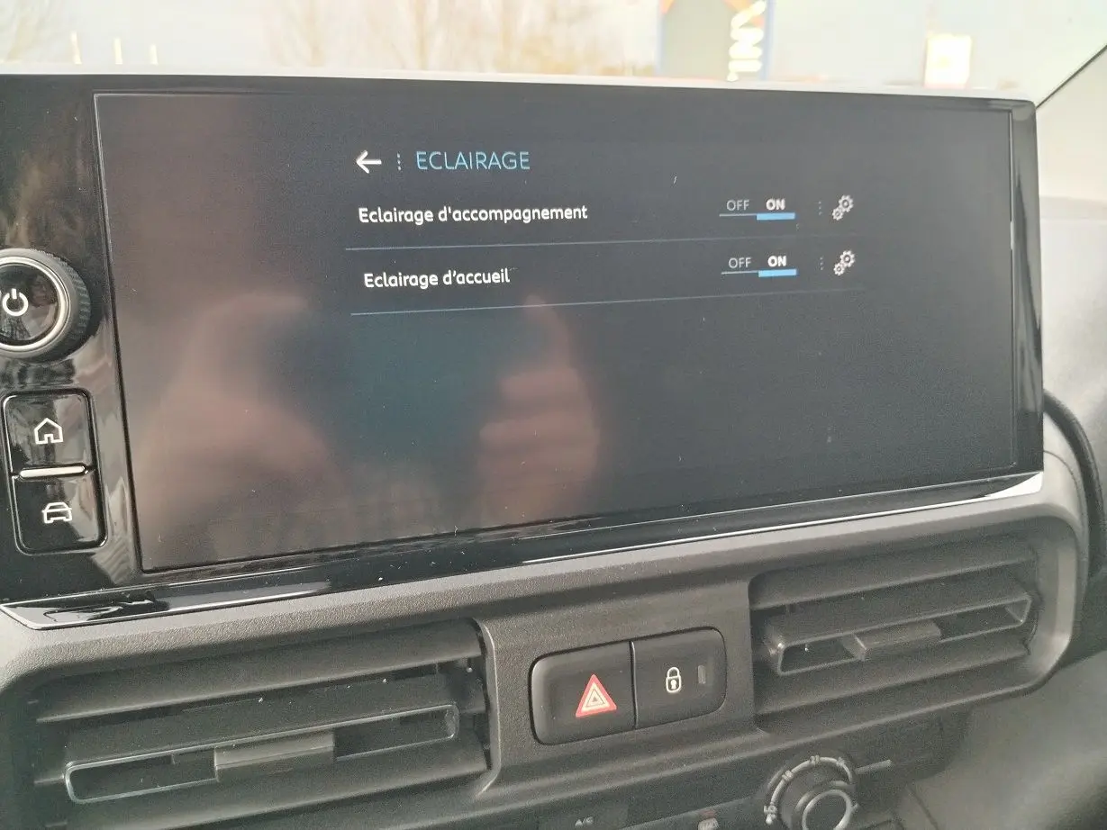 Écran tactile central du Peugeot Partner Fourgon 2025 affichant les réglages d’éclairage, avec les aérateurs en dessous.