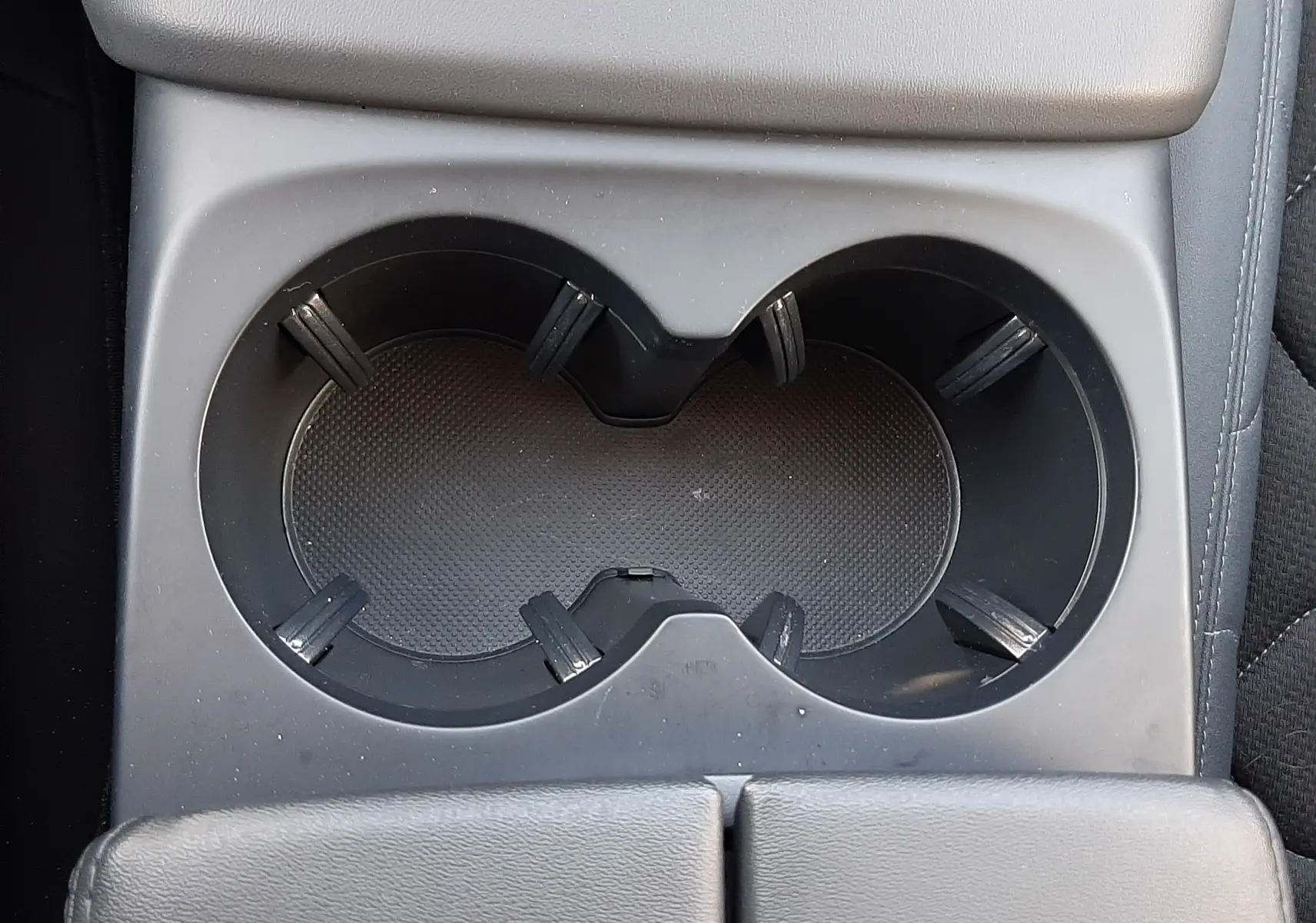 Gros plan sur les porte-gobelets centraux noirs du Citroën C5 Aircross 2024, intérieur en cuir gris.