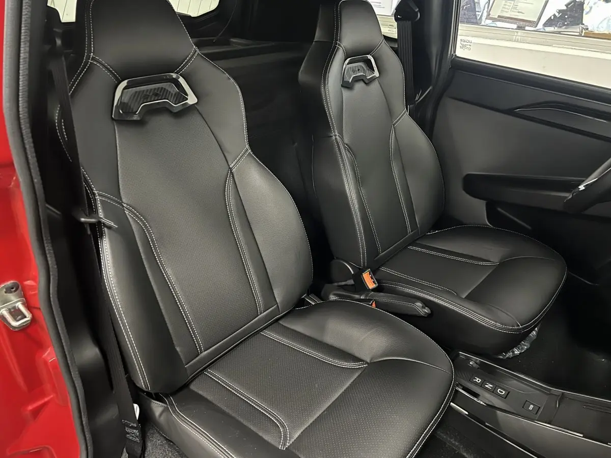 Vue intérieure côté droit montrant les sièges noirs en cuir du LIGIER JS50 BEV 8KWH ELITE rouge 2025 avec boîte auto.
