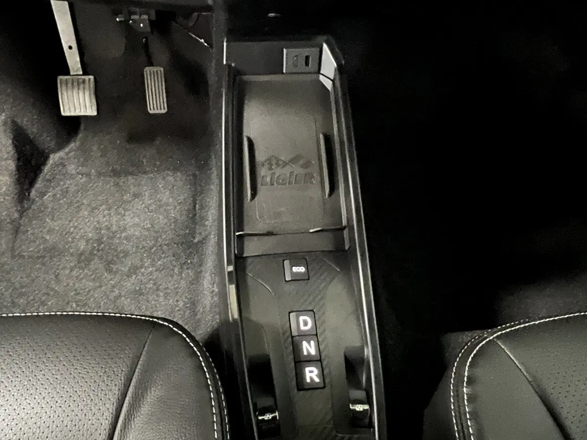 Vue rapprochée de la console centrale noire avec sélecteur de boîte auto D, N, R et bouton Eco sur LIGIER JS50 rouge.