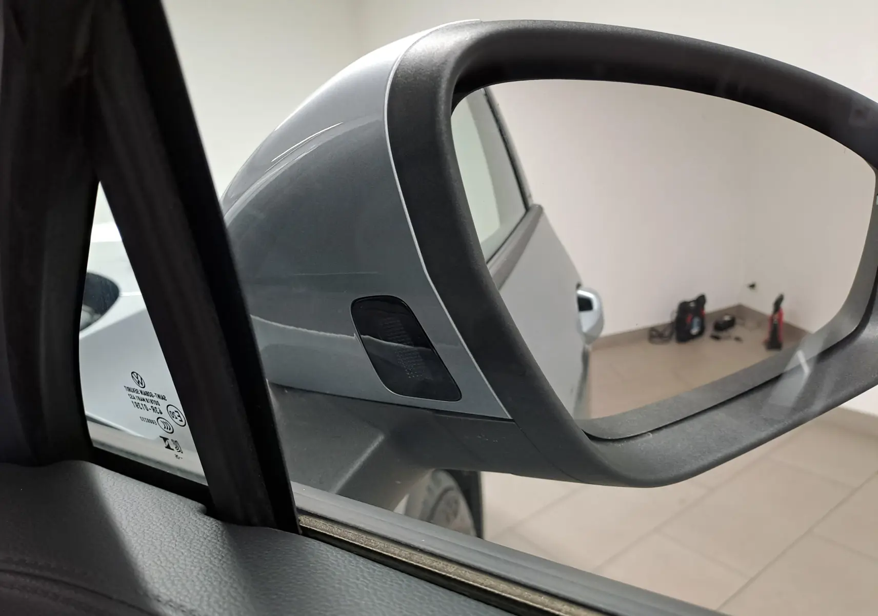 Gros plan sur le rétroviseur côté gauche d’un Volkswagen Tiguan 2025 argent Dolomite avec clignotant intégré.