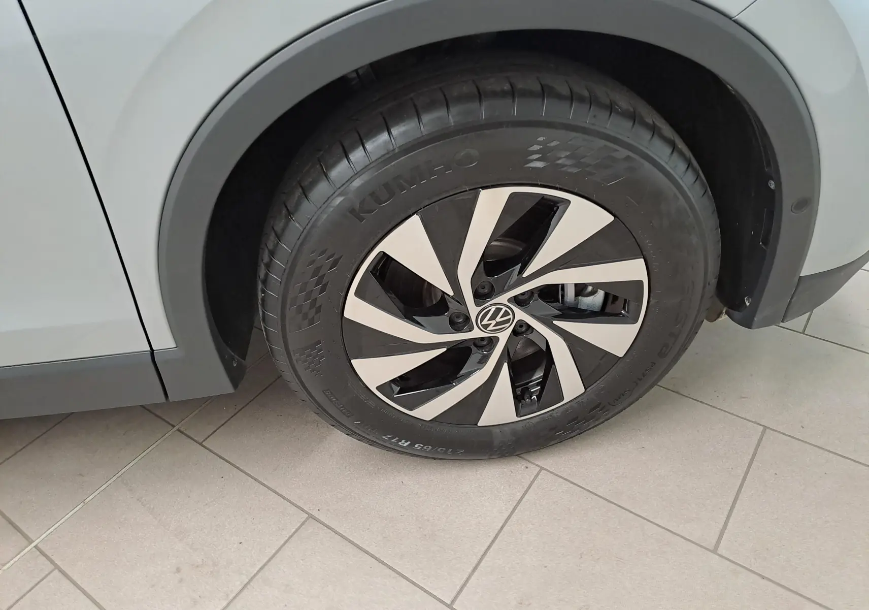 Gros plan sur la roue avant droite du Volkswagen Tiguan 2.0 TDI 150 DSG7 VW Edition argent Dolomite avec jante alliage bicolore.