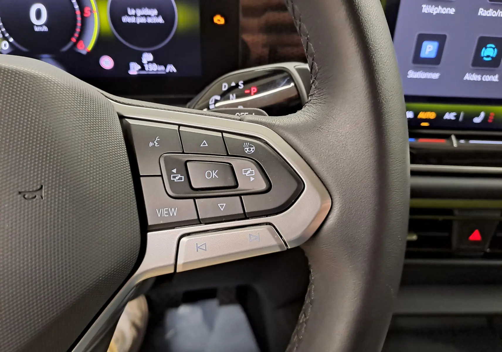 Gros plan sur le volant côté gauche du Volkswagen Tiguan 2.0 TDI 150 DSG7 avec commandes multifonctions et volant chauffant.