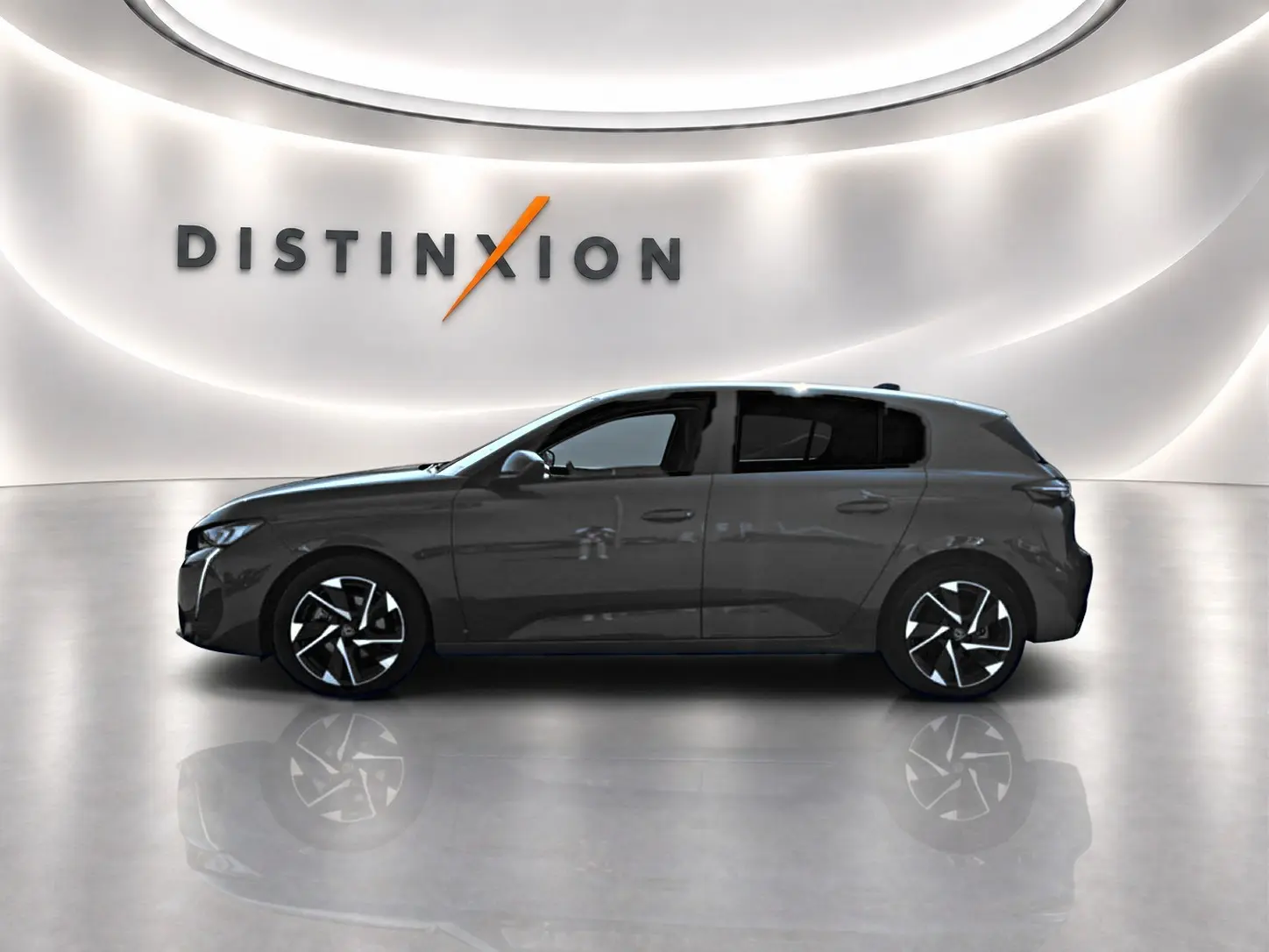 Profil côté gauche de la Peugeot 308 gris métallisé 2025 avec jantes alliage et vitres arrière surteintées dans un showroom.