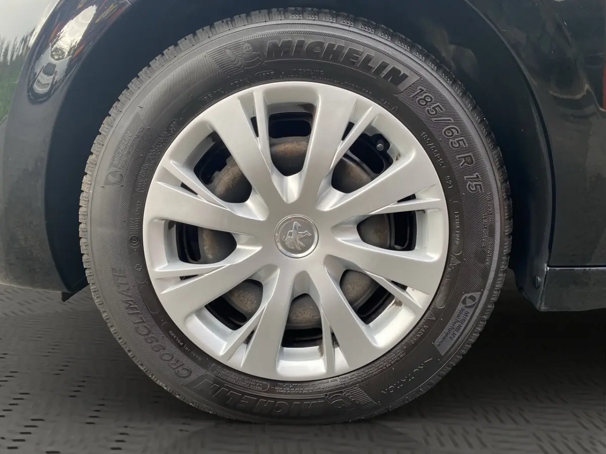 Gros plan sur la roue avant gauche noire d'une Peugeot 208 Affaire avec jante en alliage argenté et pneu Michelin.