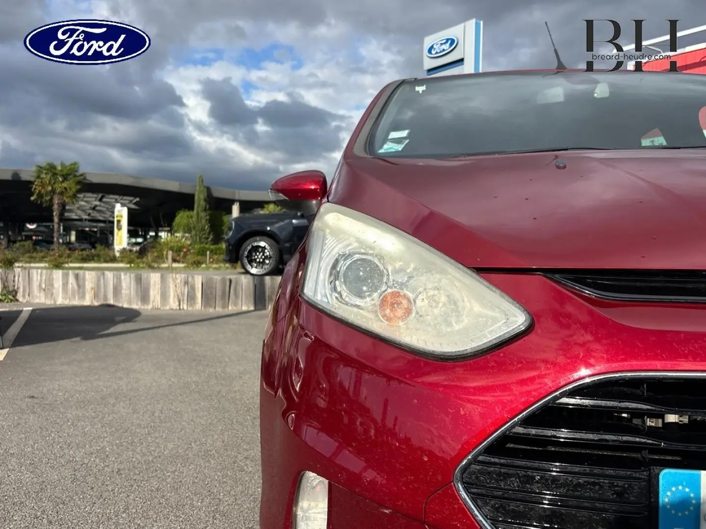 Vue avant droite d'une Ford B-MAX 2017 en rouge Premium Candy avec calandre chromée et phares halogènes.