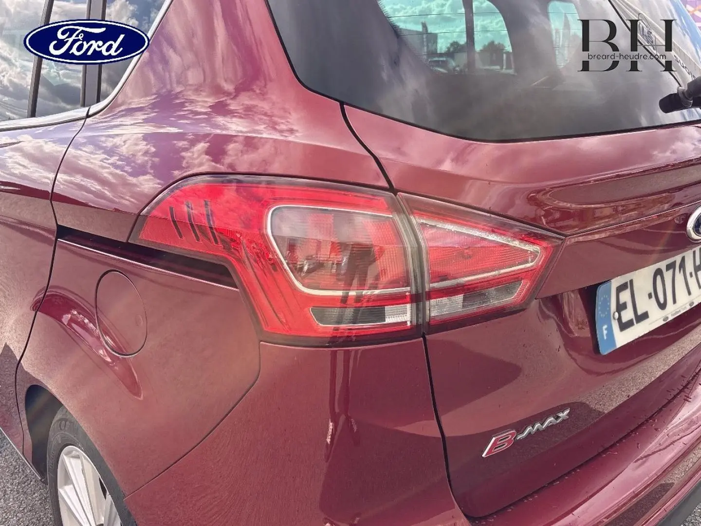 Vue 3/4 arrière droite d'une Ford B-MAX 2017 en rouge Premium Candy avec feux arrière et jantes alu visibles.