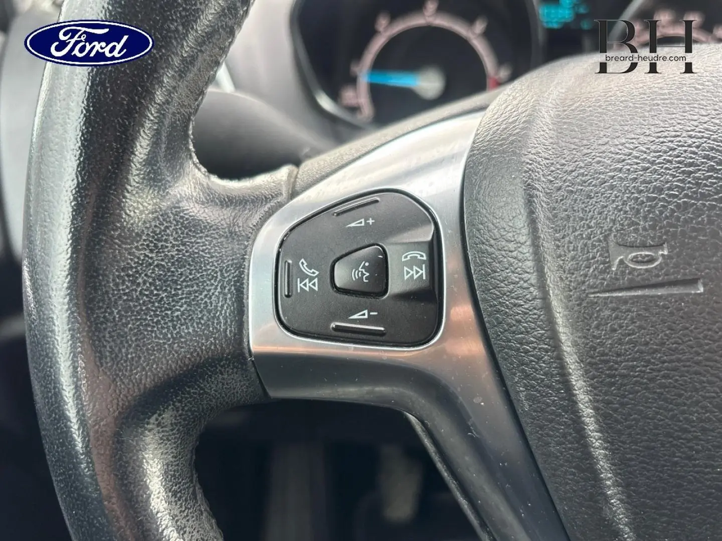 Gros plan sur le volant en cuir noir de la Ford B-MAX avec commandes audio et vocales intégrées.