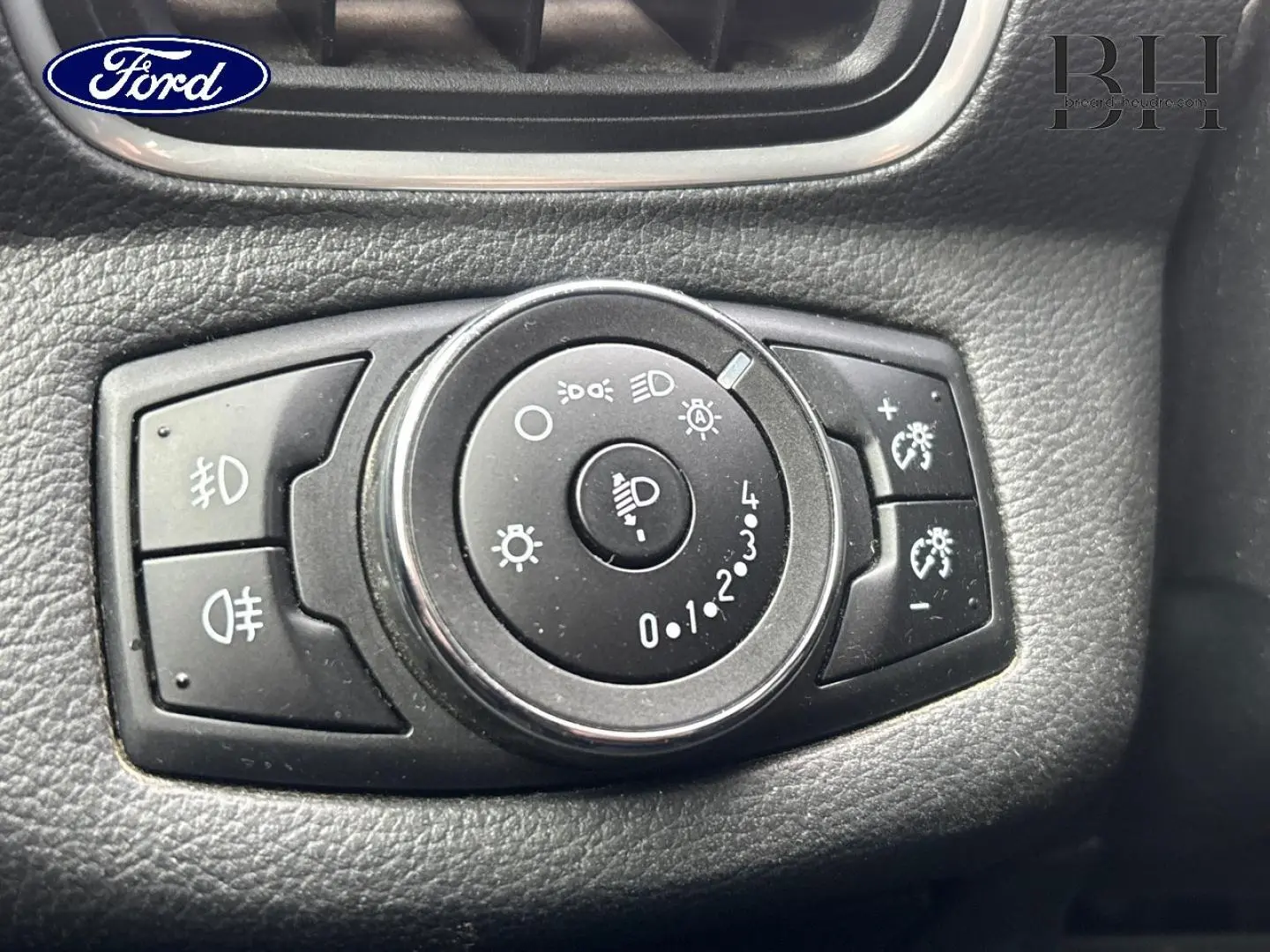 Gros plan sur la molette de réglage des phares du Ford B-MAX 2017, entourée de boutons noirs sur tableau de bord noir.