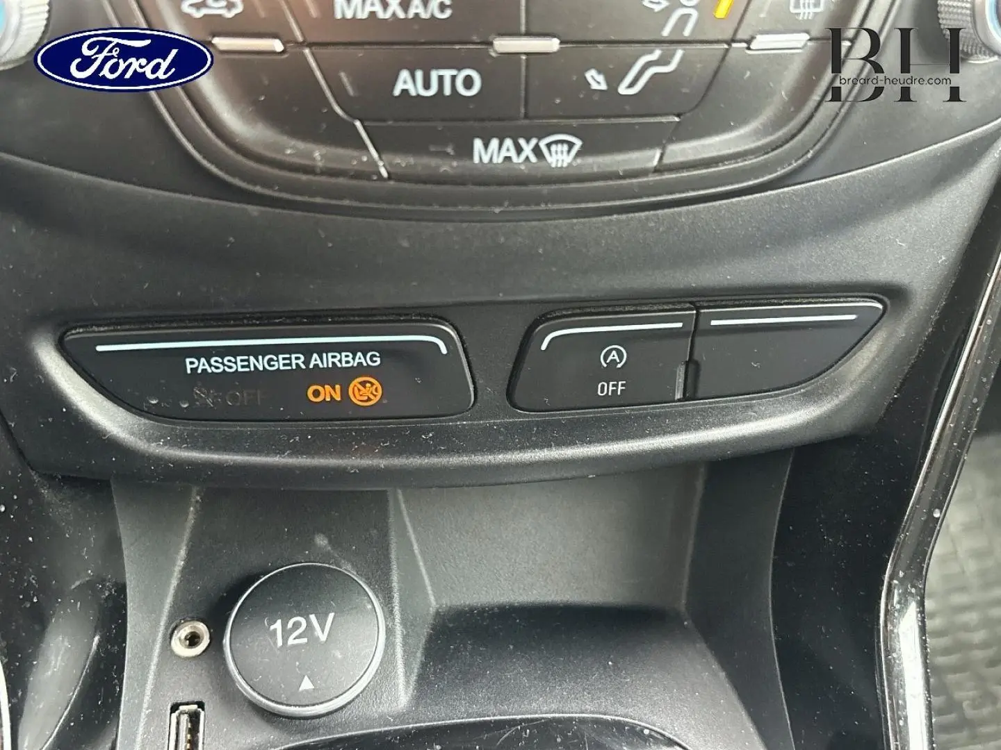 Détail intérieur du Ford B-MAX 2017 montrant la console centrale avec prise 12V et voyants airbag et arrêt auto du moteur.