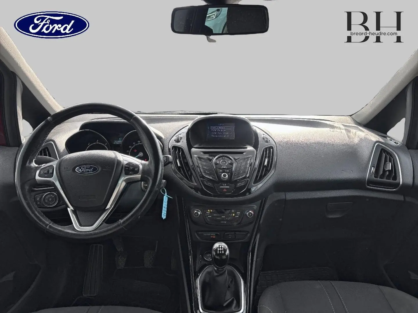Vue intérieure avant du tableau de bord et volant cuir multifonction du Ford B-MAX 1.5 TDCi rouge avec boîte manuelle.