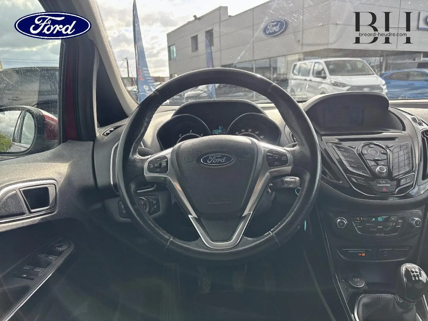 Vue intérieure centrée sur le volant cuir multifonction et la console centrale du Ford B-MAX Premium Rouge Candy 2017.