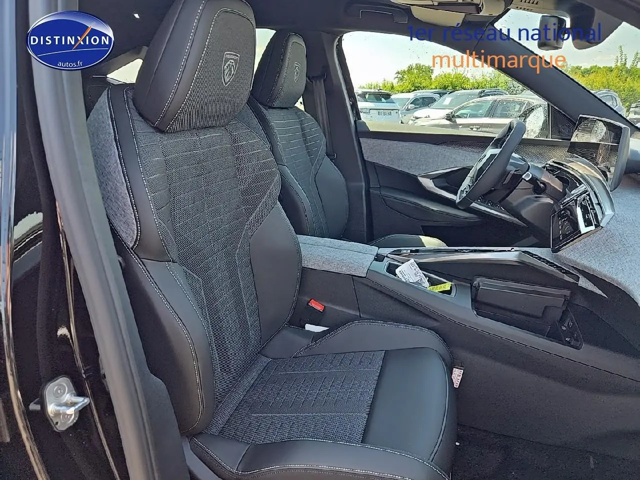 Vue intérieure côté conducteur du Peugeot 3008 2025, sièges tissu et cuir noir avec logo Peugeot brodé sur appuie-tête.