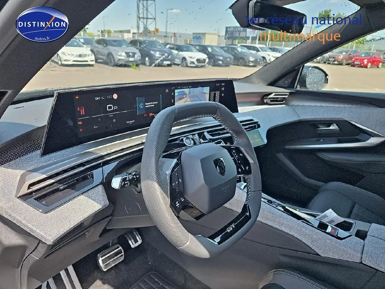 Vue intérieure du poste de conduite du Peugeot 3008 noir 2025, volant cuir GT et écran tactile panoramique.