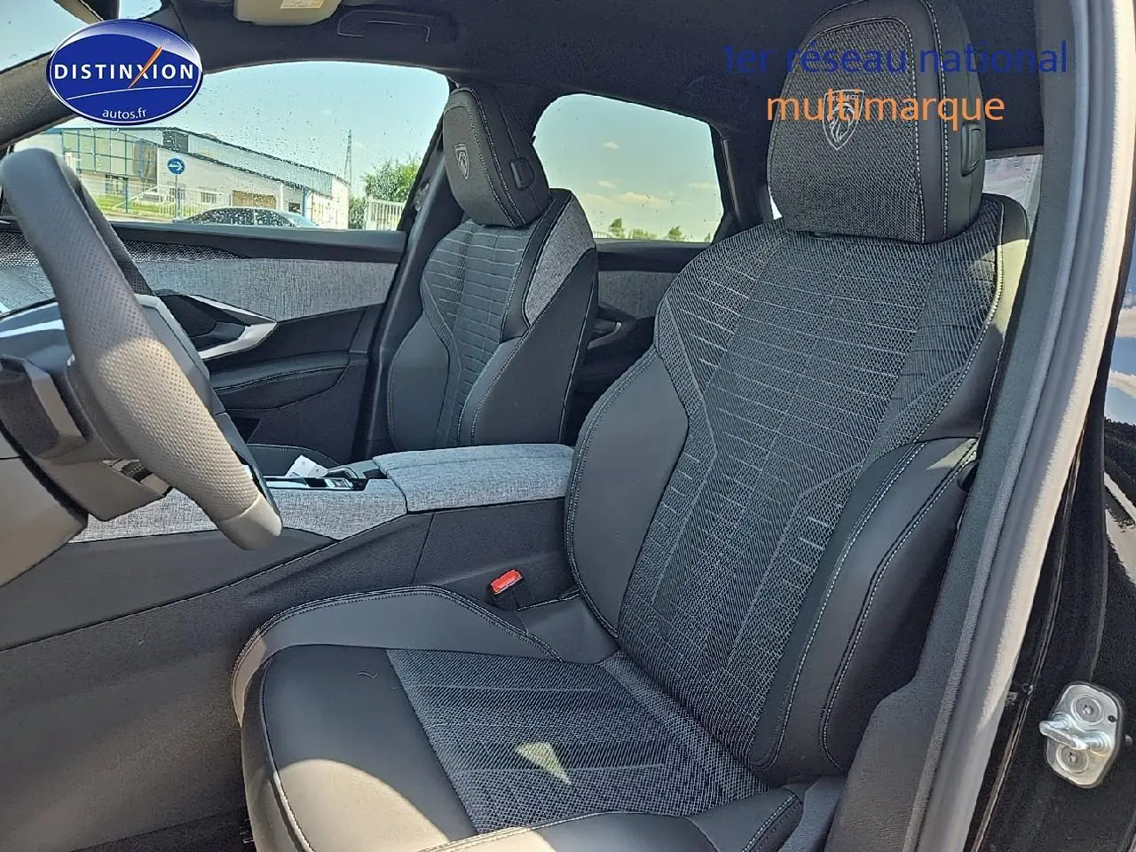 Intérieur du Peugeot 3008 2025 noir, vue côté droit sur sièges avant en tissu et cuir avec logo brodé sur appuie-tête