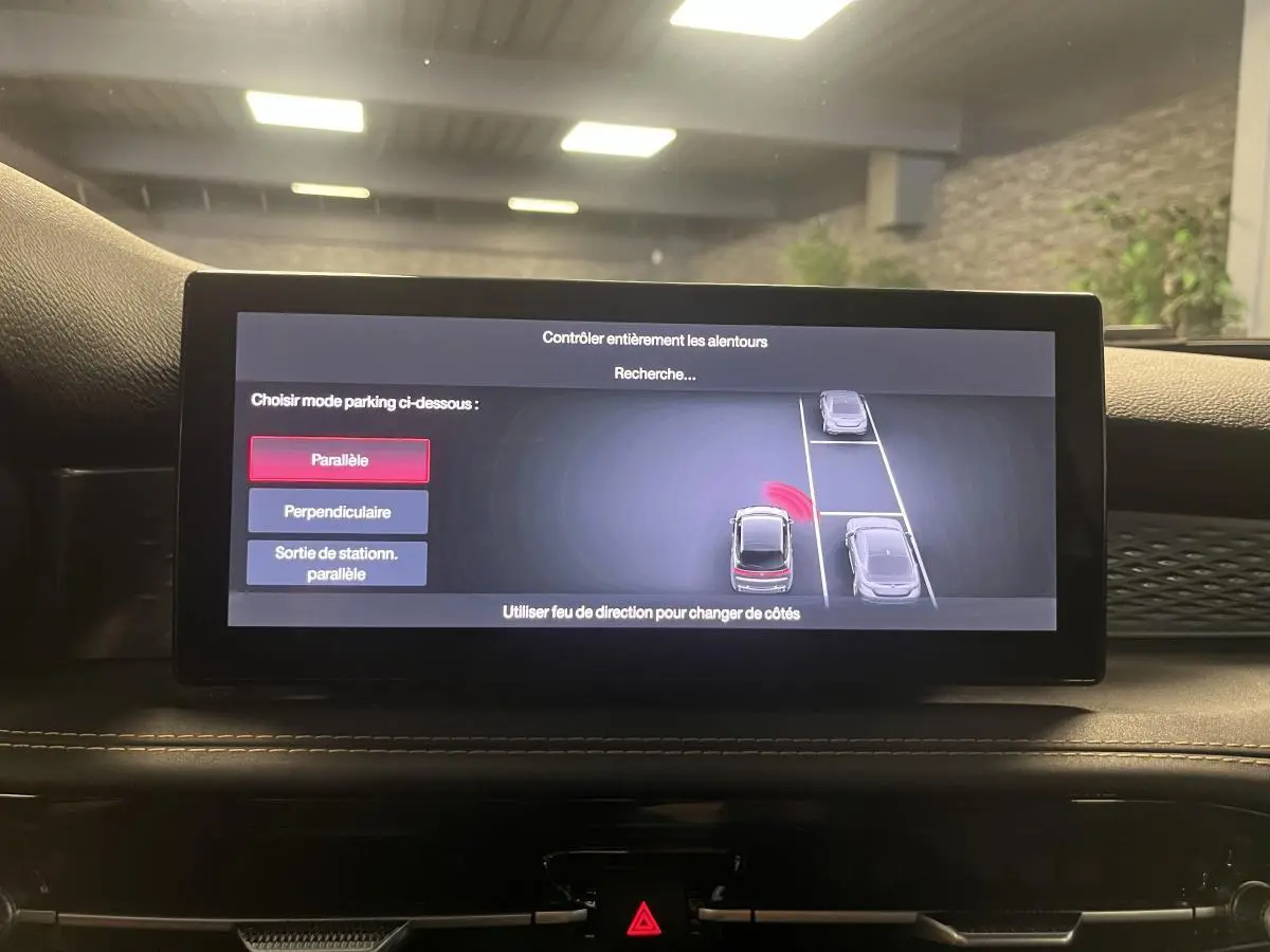 Écran central de l'Alfa Romeo Tonale 2024 montrant l'assistance au stationnement avec vue sur le tableau de bord noir.