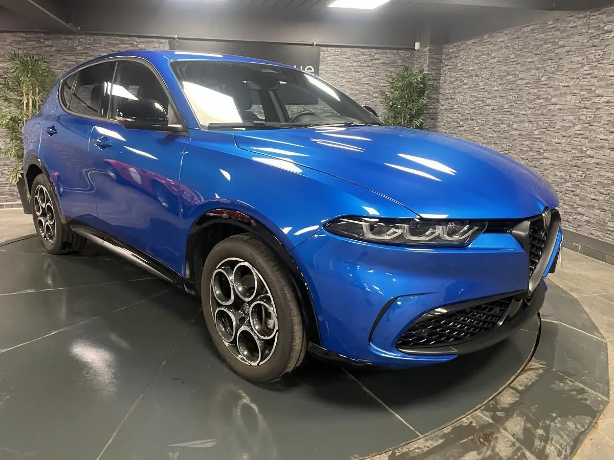 Alfa Romeo Tonale bleu en 3/4 avant droit, avec jantes alliage 18 pouces et calandre noire distinctive.