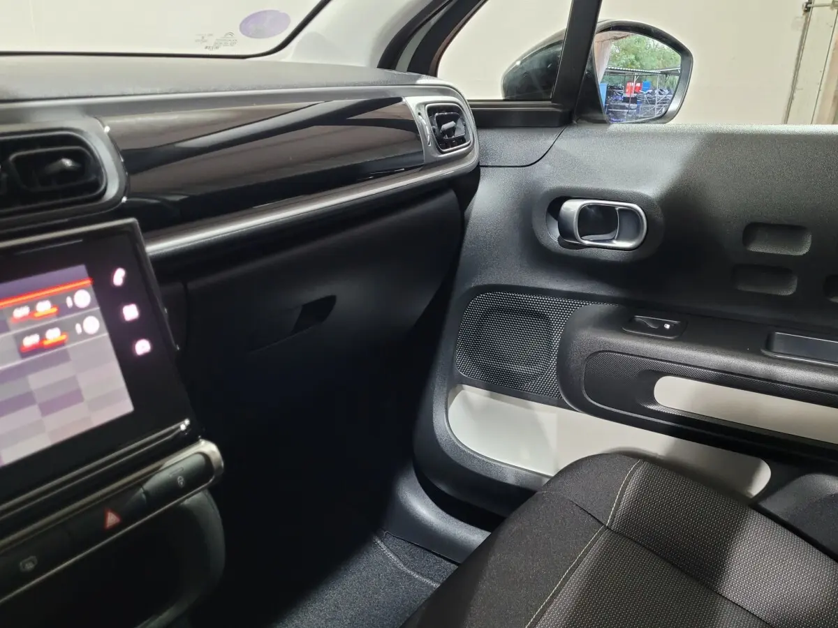 Intérieur avant droit de la Citroën C3 beige 2022, avec tableau de bord noir brillant et écran tactile visible.