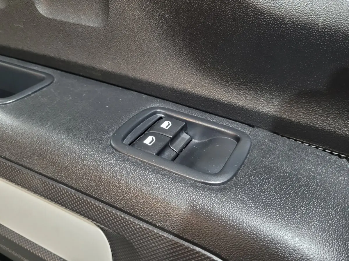 Gros plan sur les commandes de verrouillage des portes côté conducteur de la Citroën C3 beige 2022.