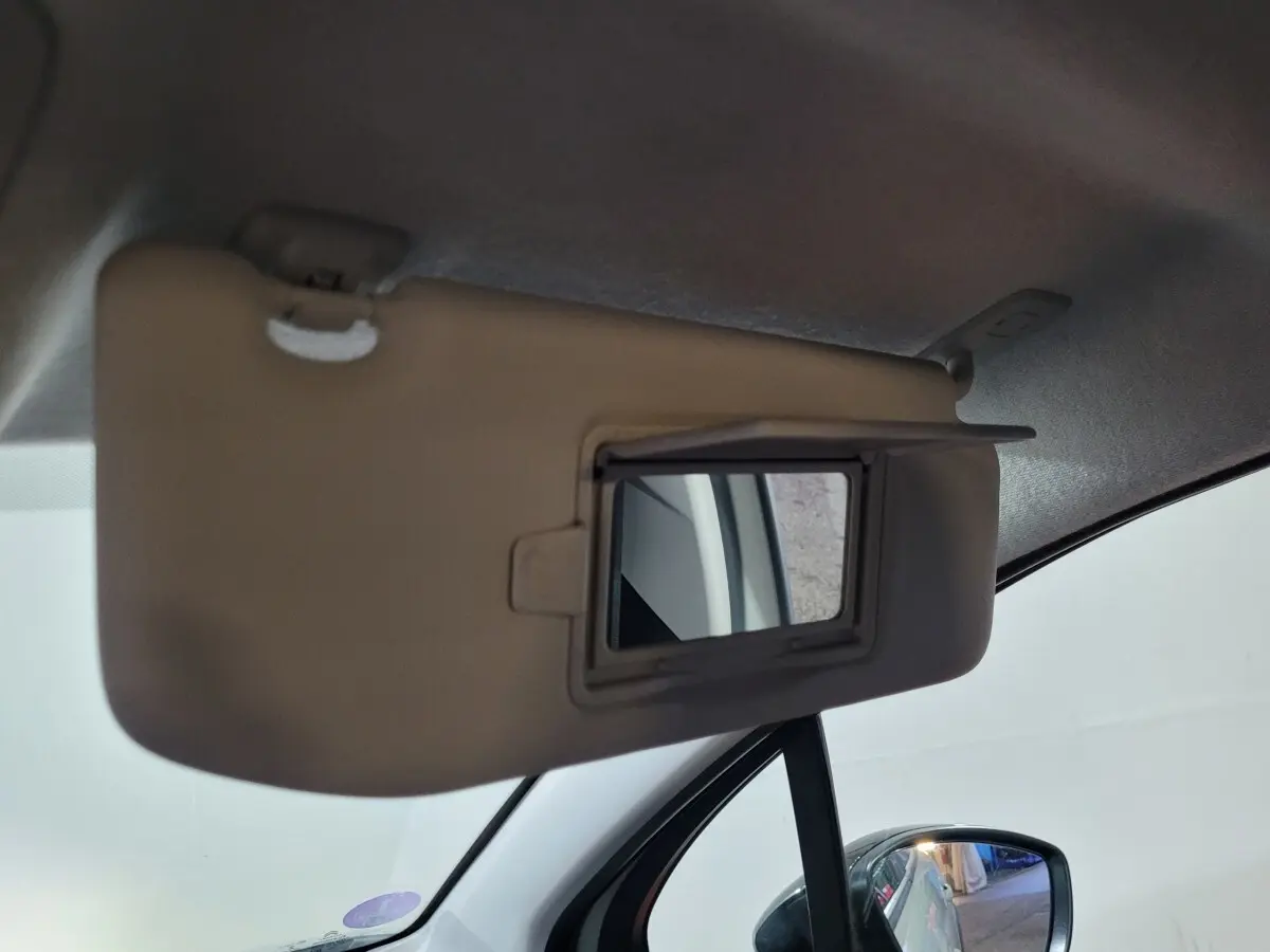 Miroir de courtoisie sur pare-soleil côté conducteur d'une Citroën C3 beige, intérieur vue rapprochée.