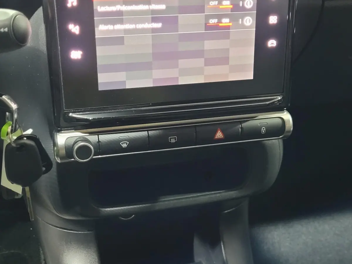 Gros plan sur la console centrale noire de la Citroën C3 avec écran tactile et commandes de climatisation visibles
