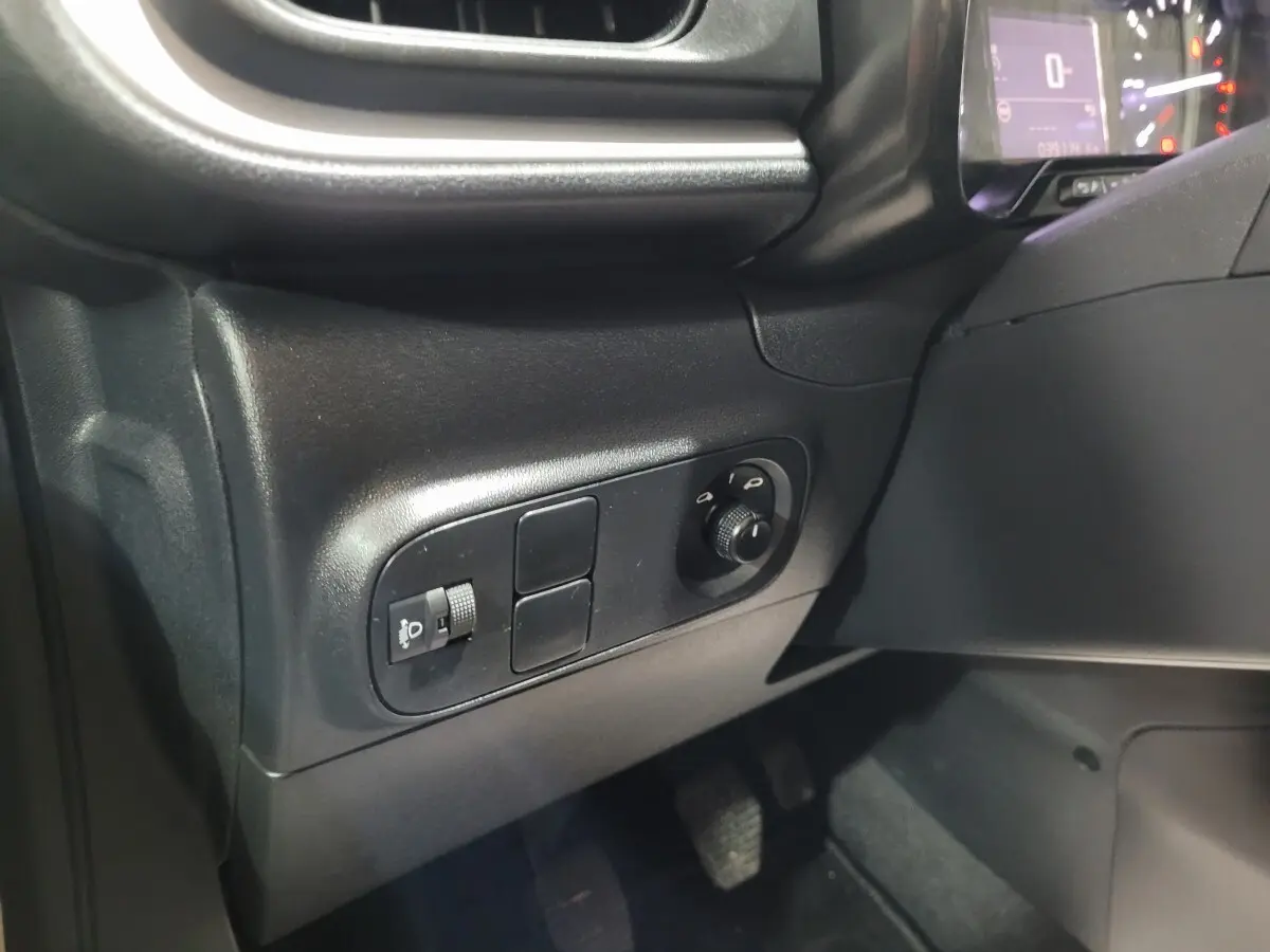 Vue intérieure côté gauche du tableau de bord de la Citroën C3 beige 2022 avec commandes des phares et réglage hauteur.