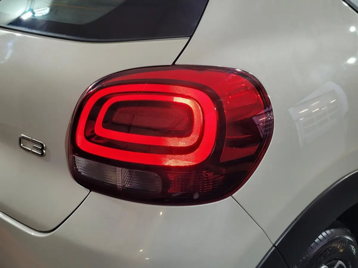Gros plan sur le feu arrière droit rouge d'une Citroën C3 beige 2022 avec logo C3 visible sur la carrosserie.