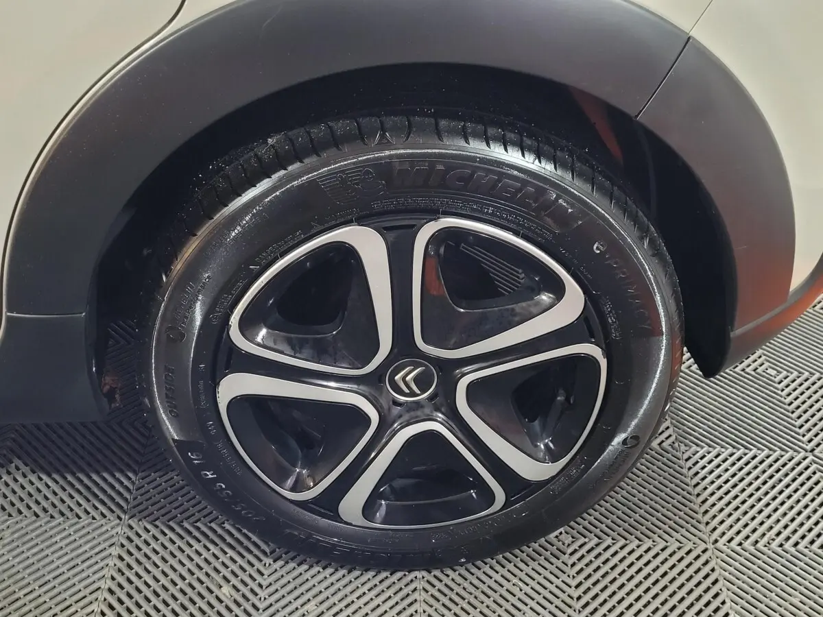 Gros plan sur la roue arrière droite beige d'une Citroën C3 avec jante noire et argentée au design moderne.