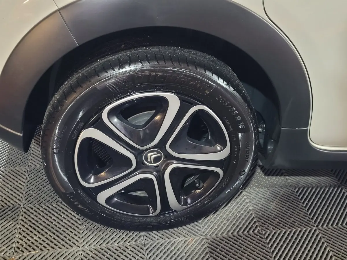 Gros plan sur la roue avant droite beige d'une Citroën C3 2022 avec jante noire et argentée au design moderne.