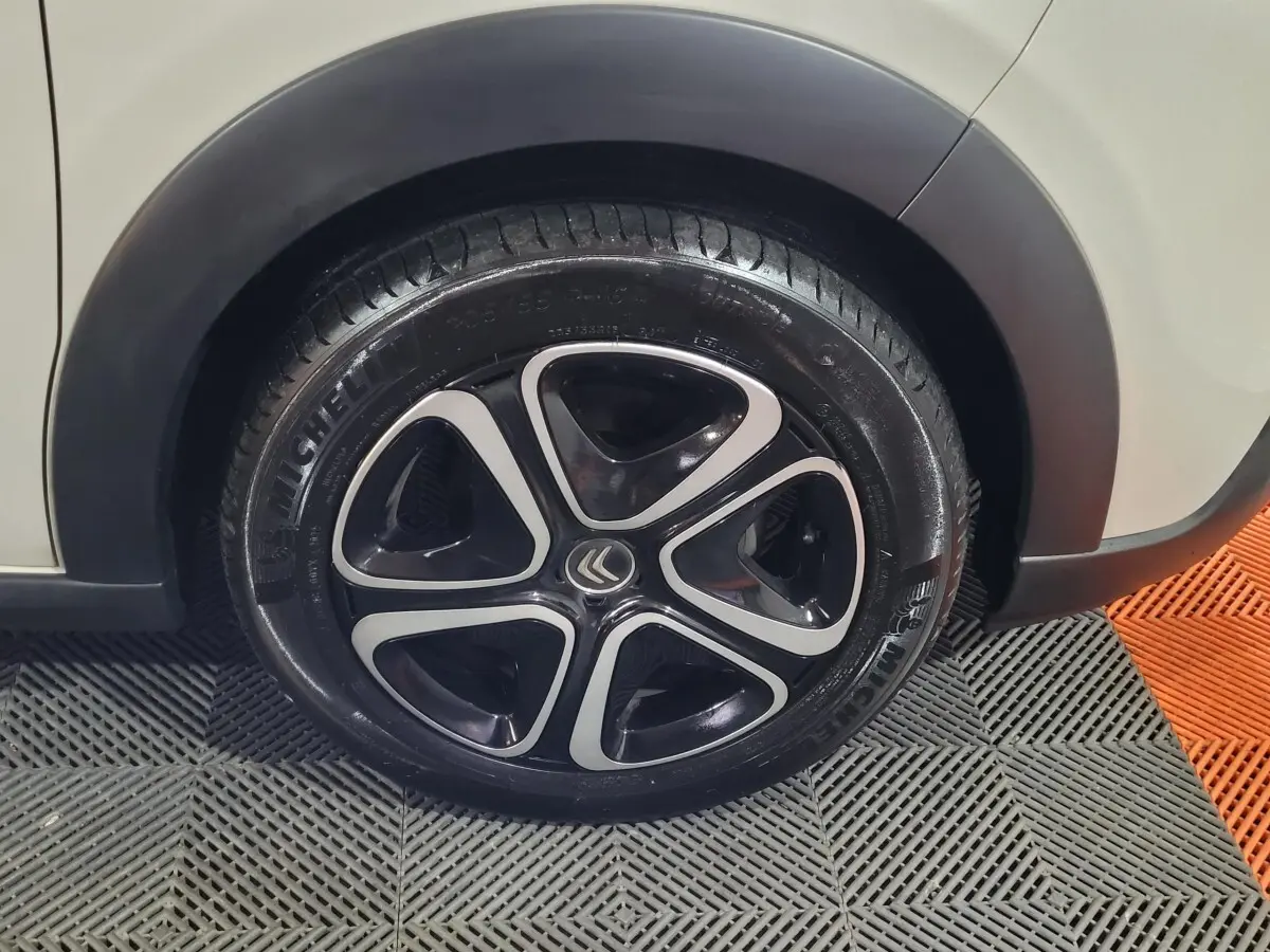 Gros plan sur la roue avant gauche beige d'une Citroën C3 2022 avec jante noire et argentée au design moderne.