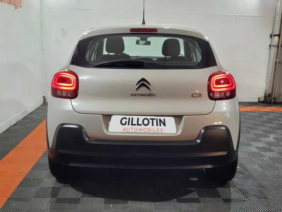 Vue arrière d'une Citroën C3 beige 2022 avec feux arrière LED allumés dans un garage.