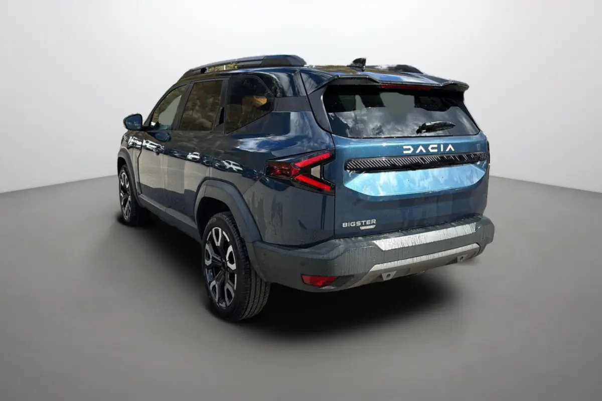 Vue 3/4 arrière droite du Dacia Bigster Hybrid 155 bleu indigo avec toit noir et jantes alu 19 pouces.