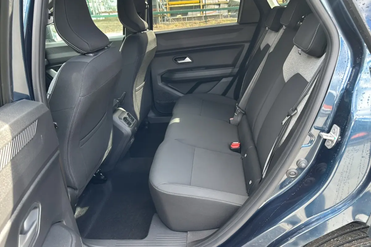Vue côté droit de la banquette arrière noire du Dacia Bigster Hybrid 155 Journey Plus bleu indigo avec porte ouverte.