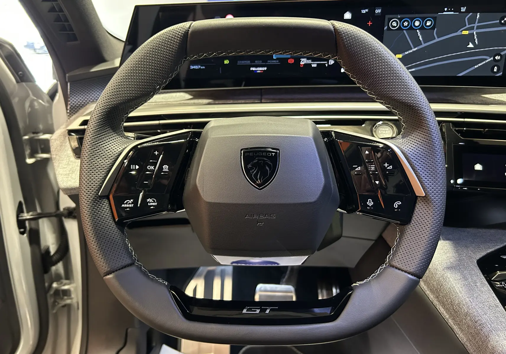 Vue rapprochée du volant GT en cuir perforé avec commandes intégrées du Peugeot 3008 III Hybrid blanc Okenite.